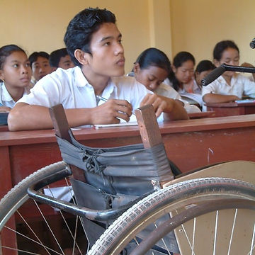 A child in a wheelchair in a classroom
Description automatically generated